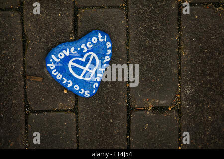 Dipinte a mano "Amore Scozia' pebble sul percorso in corrispondenza di Giove Artland, Edimburgo, Scozia. Foto Stock