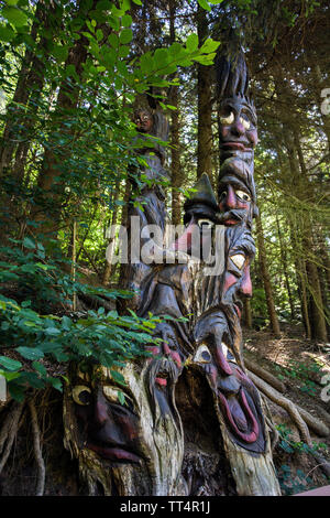 Facce intagliato in un tronco di albero, foresta fantasmi trail (tedesco: Waldgeisterweg), Oberotterbach, Itinerario dei vini tedeschi, Renania-Palatinato, Germania Foto Stock