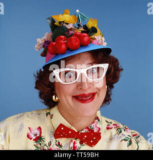 Crazy da stupidi donna che indossa un cappello fatto di frutta Foto Stock