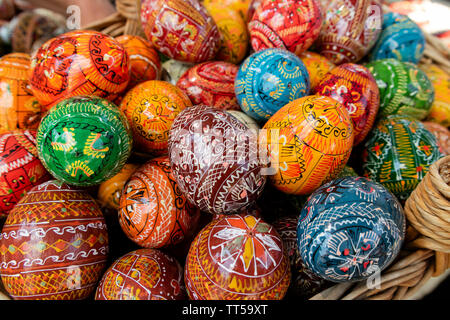 Bucovina, Romania - August 5th, 2018: un cesto pieno di tradizionalmente decorata in legno di uova di pasqua in esposizione su un mercato in stallo Bucovina, Romania Foto Stock