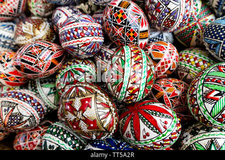 Bucovina, Romania - August 5th, 2018: un cesto pieno di tradizionalmente decorata in legno di uova di pasqua in esposizione su un mercato in stallo Bucovina, Romania Foto Stock