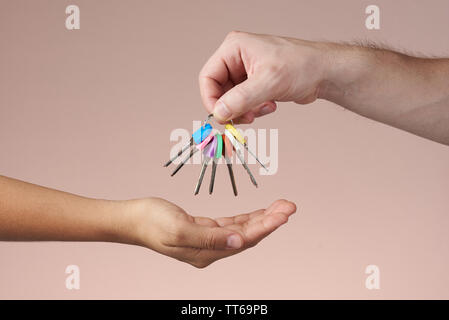 Il passaggio di mano gruppo di tasti colorati isolato su sfondo marrone Foto Stock