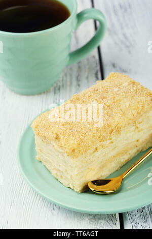 Torta di Napoleone sulla piastra e la tazza di tè sul tavolo di close-up Foto Stock