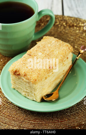 Torta di Napoleone sulla piastra e la tazza di tè sul tavolo di close-up Foto Stock