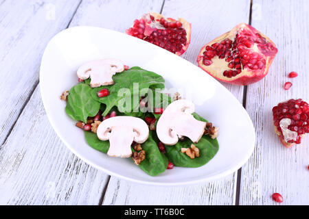 Insalata fresca con verdi, granato e spezie su lastra sul tavolo di close-up Foto Stock