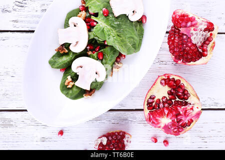 Insalata fresca con verdi, granato e spezie su lastra sul tavolo di close-up Foto Stock