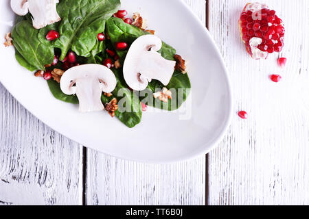 Insalata fresca con verdi, granato e spezie su lastra sul tavolo di close-up Foto Stock