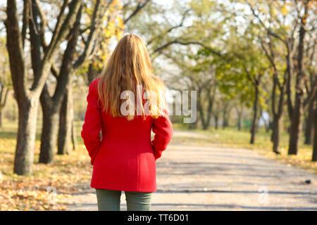 Donna solitarie passeggiate nel parco Foto Stock