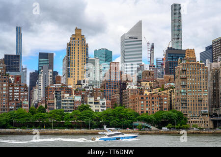 New York, Stati Uniti d'America, 14 giugno 2019. Una crociere in barca attraverso il Fiume Est di fronte agli edifici di New York City di Manhattan tra cui il Citicorp headqua Foto Stock