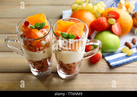 Sana dessert a strati con muesli e frutta sul tavolo Foto Stock
