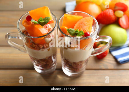 Sana dessert a strati con muesli e frutta sul tavolo Foto Stock