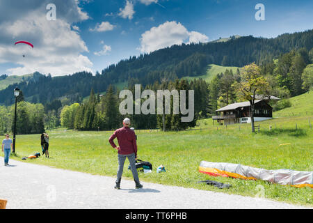 Schwarzsee FR / Svizzera - 1 Giugno 2019: istruttori e studenti lavorano insieme durante un corso di formazione per il parapendio nelle Alpi svizzere di Fribo Foto Stock