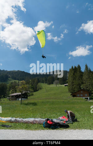 Schwarzsee FR / Svizzera - 1 Giugno 2019: istruttori e studenti lavorano insieme durante un corso di formazione per il parapendio nelle Alpi svizzere di Fribo Foto Stock