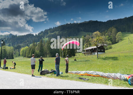 Schwarzsee FR / Svizzera - 1 Giugno 2019: istruttori e studenti lavorano insieme durante un corso di formazione per il parapendio nelle Alpi svizzere di Fribo Foto Stock