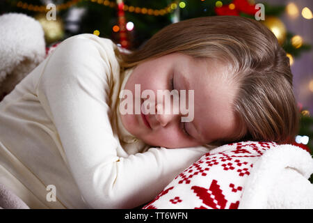 Bambina di dormire su albero di Natale sfondo Foto Stock