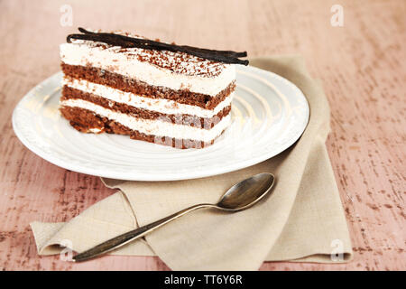 Gustosa torta tiramisù sulla piastra, sul tavolo di legno Foto Stock