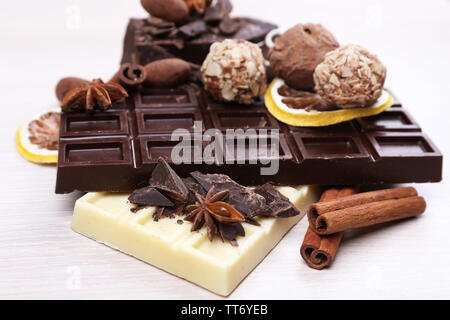 Pezzi di cioccolato con limone e bastoncini di cannella su sfondo di legno Foto Stock