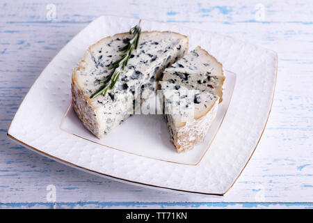 Formaggio blu con rametti di rosmarino su piastra e in legno di colore di sfondo della tabella Foto Stock