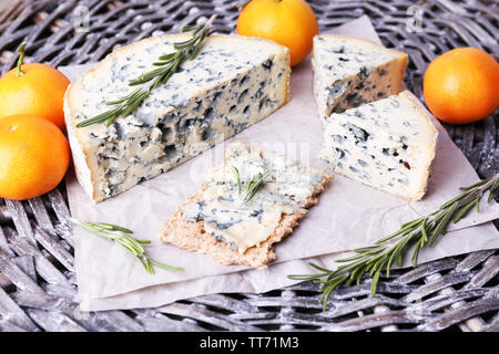 Formaggio blu con rametti di rosmarino e le arance in vimini sfondo mat Foto Stock