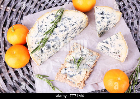 Formaggio blu con rametti di rosmarino e le arance in vimini sfondo mat Foto Stock