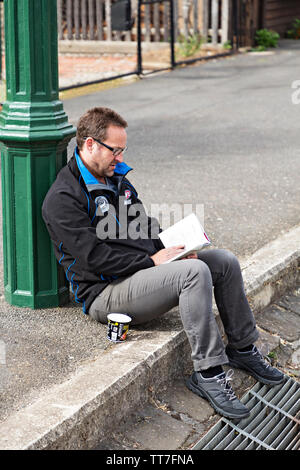 Un uomo legge un libro a Clunes Booktown festival in 1850 gold città mineraria di Clunes in Victoria Australia. Foto Stock