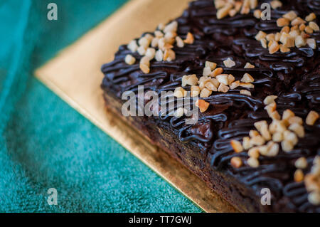 Torta al cioccolato Brownie piazze spruzzata con la cioccolata Nutella e noci. Vista ingrandita, il fuoco selettivo Foto Stock