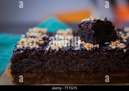 Torta al cioccolato Brownie piazze spruzzata con la cioccolata Nutella e noci. Vista ingrandita, il fuoco selettivo Foto Stock