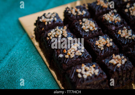 Torta al cioccolato Brownie piazze spruzzata con la cioccolata Nutella e noci. Vista ingrandita, il fuoco selettivo Foto Stock