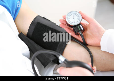 Medico di misurazione pressione del paziente da vicino Foto Stock