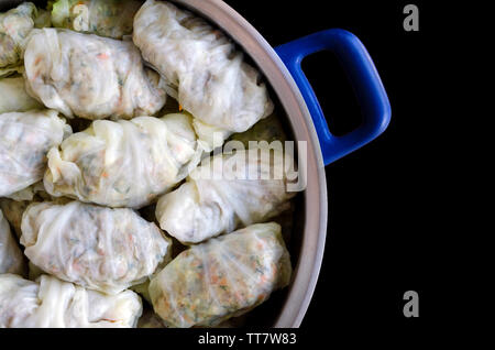 Involtini di cavolo o Dolma. Farcite le foglie di cavolo con carne macinata, riso, verdure ed erbe in una casseruola. Isolato su backround nero con spazio di copia Foto Stock