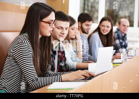 Gruppo di studenti usando i gadget in aula Foto Stock