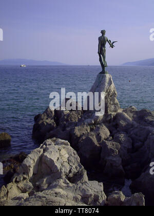 Fanciulla con Seagull permanente sulla roccia in Opatija. Vista dal lungomare di Opatija in Istria, Croazia Foto Stock