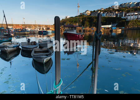 Barche ormeggiate in serata nel porto di Mevagissey, Cornwall, Regno Unito. Le barche sono riflesse in acqua calma. Foto Stock