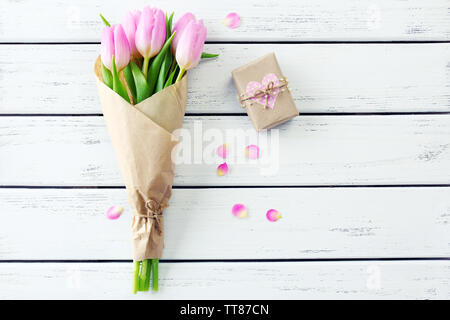 Di un bel colore rosa tulipani in carta con la presente casella su sfondo di legno Foto Stock