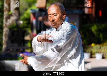 Lijiang, Cina - 27 Aprile 2019: Unidentified tai chi esercizio master con concentrato di espressione. Il tai chi è al suo interno un arte marziale cinese pratica Foto Stock