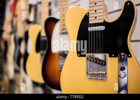 Tele vintage chitarra elettrica sulla parete a music store in vendita pronto per il rock'n'roll e blues Foto Stock