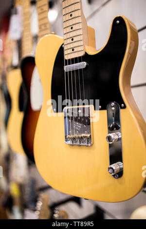 Tele vintage chitarra elettrica sulla parete a music store in vendita pronto per il rock'n'roll e blues Foto Stock