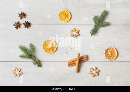 Concetto di natale con secchi Arance, anice stelle, Abete rami, fiocchi di neve e pan di zenzero bianco su sfondo di legno Foto Stock