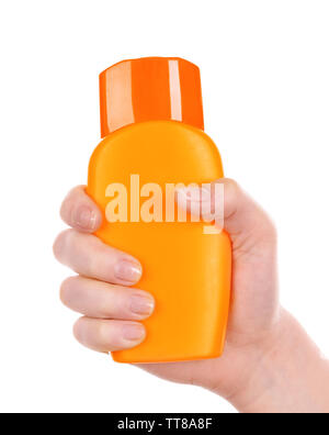 Bottiglia di creme abbronzanti in mano femmina isolato su bianco Foto Stock