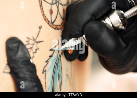 Tattooer che mostra il procedimento di preparazione di un tatuaggio, close up Foto Stock