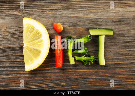 Parola dieta fatta di verdure a fettine su sfondo di legno Foto Stock