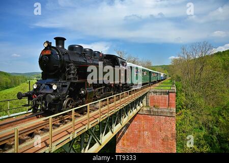 Brno, Repubblica Ceca, Maggio 19th, 2019. Bel vecchio treno a vapore la guida lungo un ponte in campagna. Nozione di viaggio, trasporto e retr Foto Stock