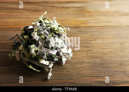 Distrutto il denaro da shredder su sfondo di legno Foto Stock