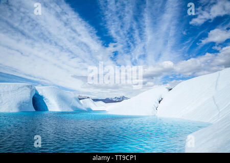 Grotta di ghiaccio allagato da profondo blu del ghiacciaio in piscina il ghiacciaio Matanuska Alaska. Il lago riempito nella caverna di ghiaccio come l'acqua dal ghiacciaio di fusione flo Foto Stock
