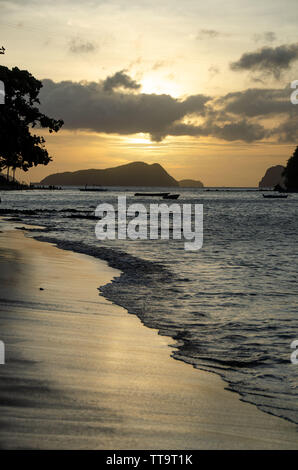 Foto scattata a las cabanas elnido guardando i colori del bellissimo tramonto sulla spiaggia e onde bellissime che bagna la riva riflessioni Foto Stock