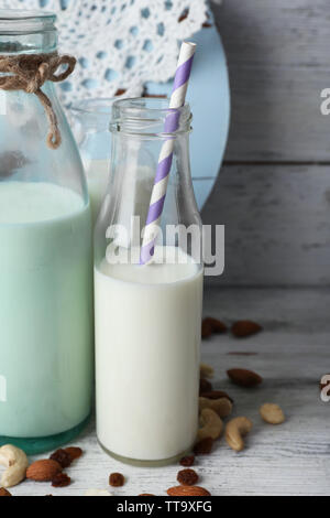 Latte in vetreria e noci su sfondo Foto Stock