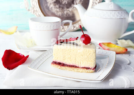 Gustoso pezzo di cheesecake su lastra sul tavolo vicino fino Foto Stock