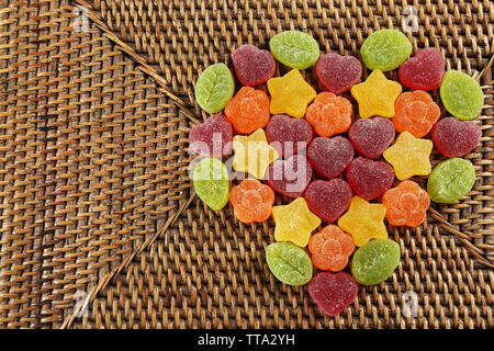 Caramelle gommose disposti in forma di cuore su sfondo di vimini Foto Stock