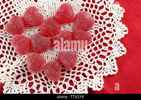 Caramelle gommose disposti in forma di cuore su sfondo di tessuto Foto Stock