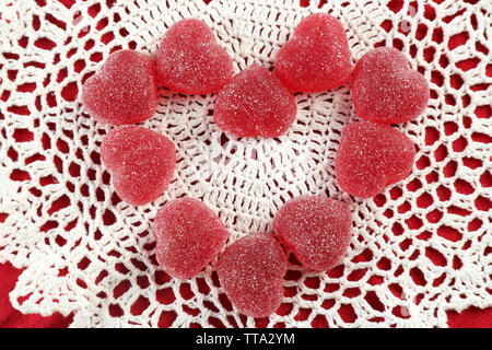 Caramelle gommose disposti in forma di cuore su sfondo di tessuto Foto Stock